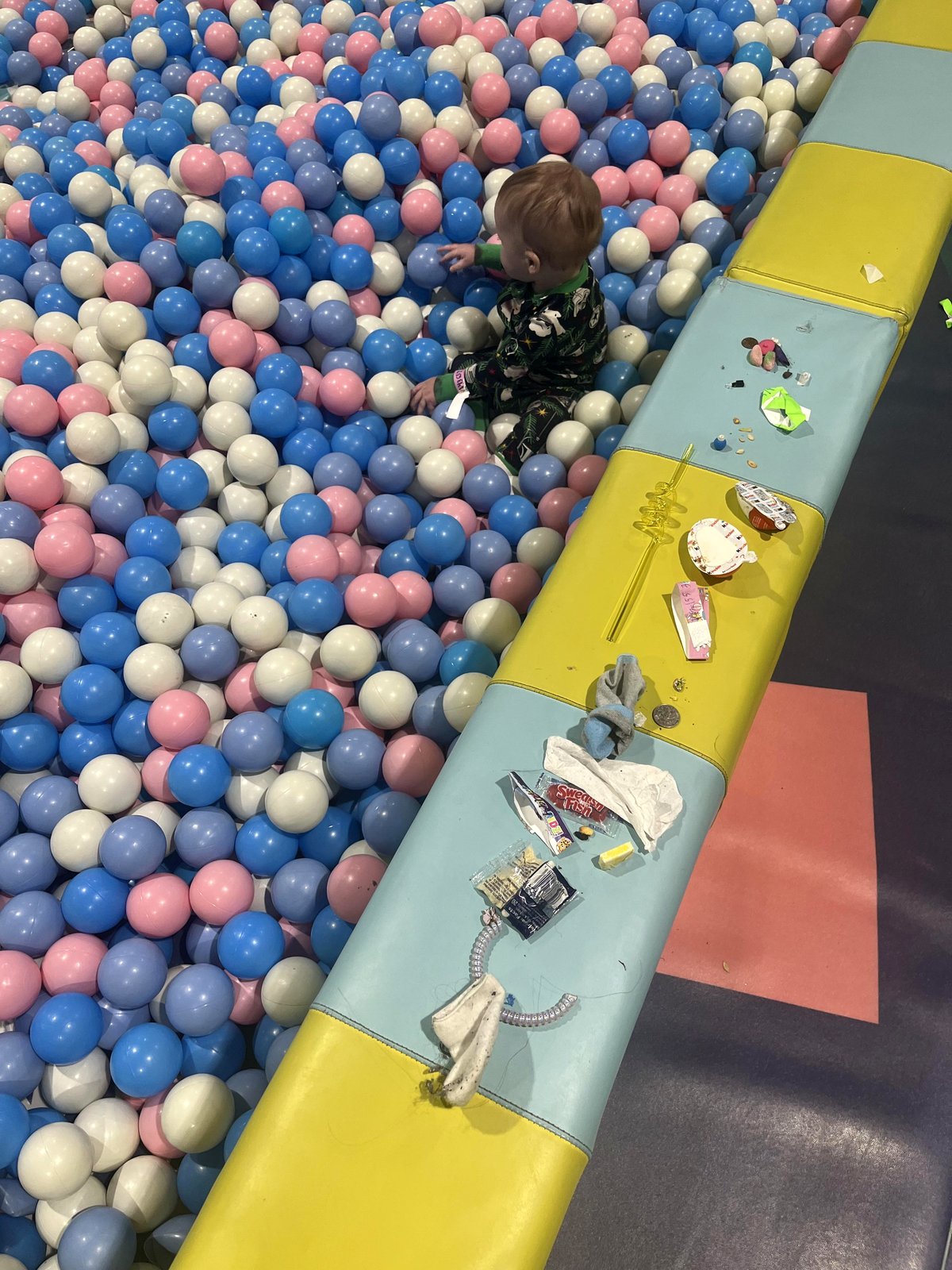 The sweetest moment found in a colorful ball pit with a baby
