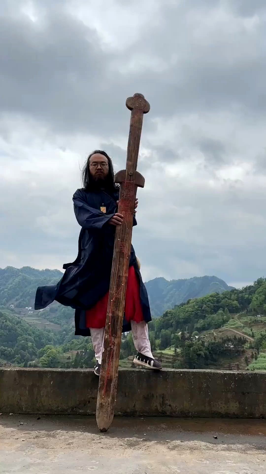 of a man wielding an enormous wooden sword… yet still manages to fall off