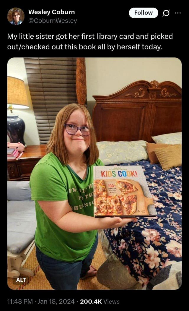 This young woman received her library card and borrowed a book on her own.