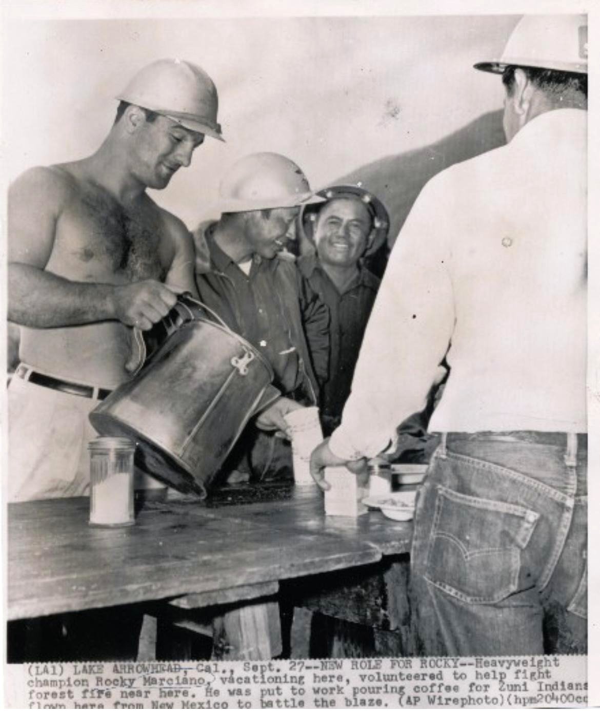 Rocky Marciano, the sole heavyweight boxing champion to retire unbeaten (49-0), serves coffee to emergency responders tackling a forest fire.